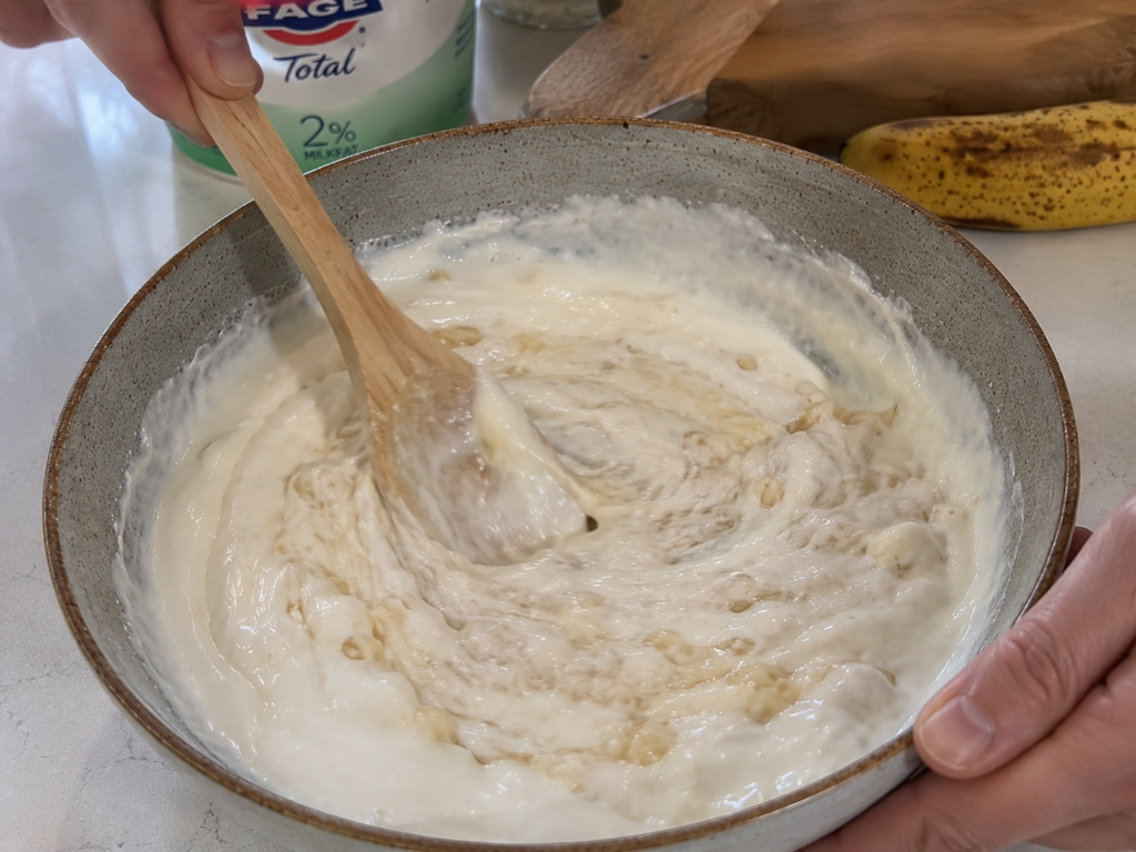 Mashing bananas and mixing with Greek yogurt for a creamy breakfast
